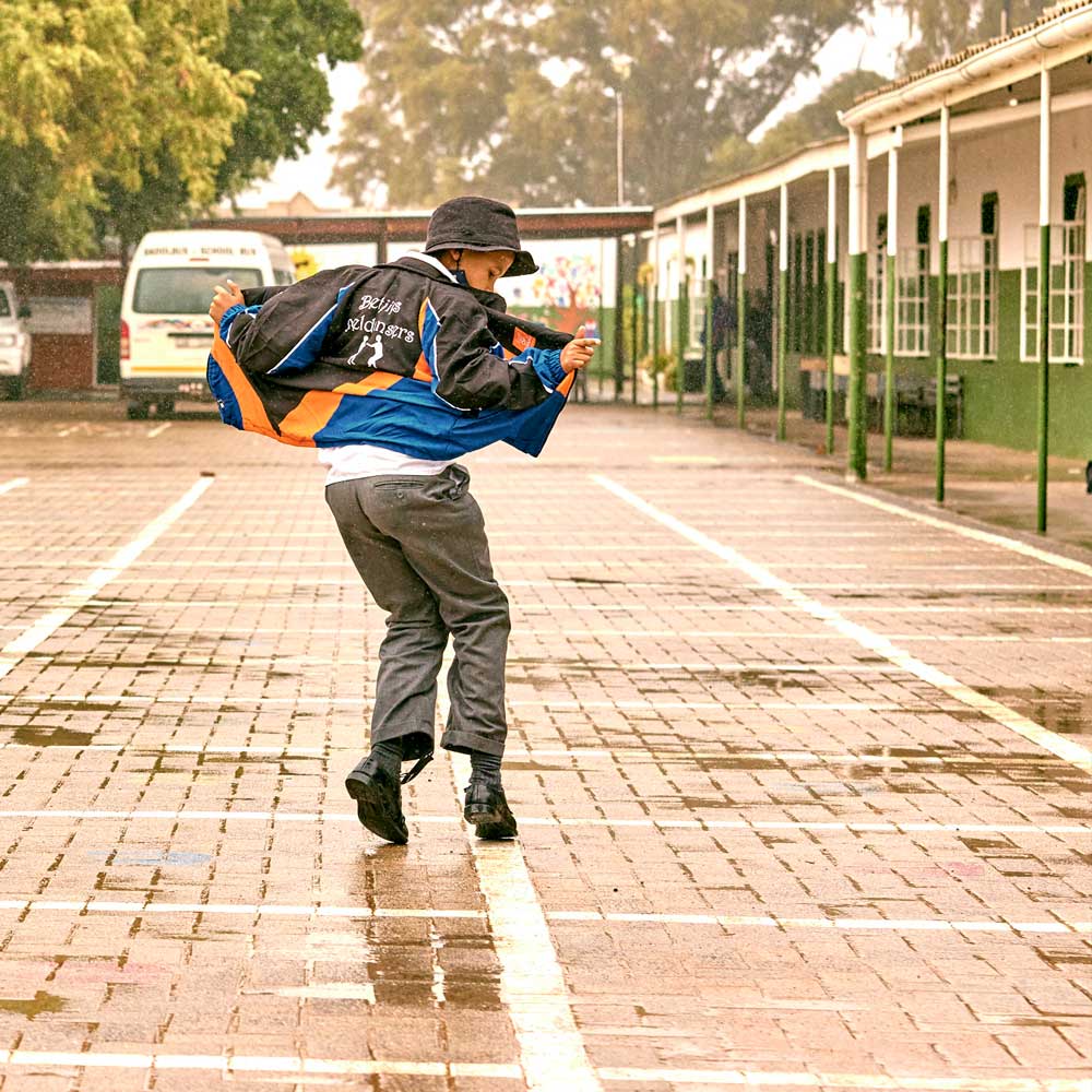 Tick Tock Giving Back Project - School boy dancing in the rain