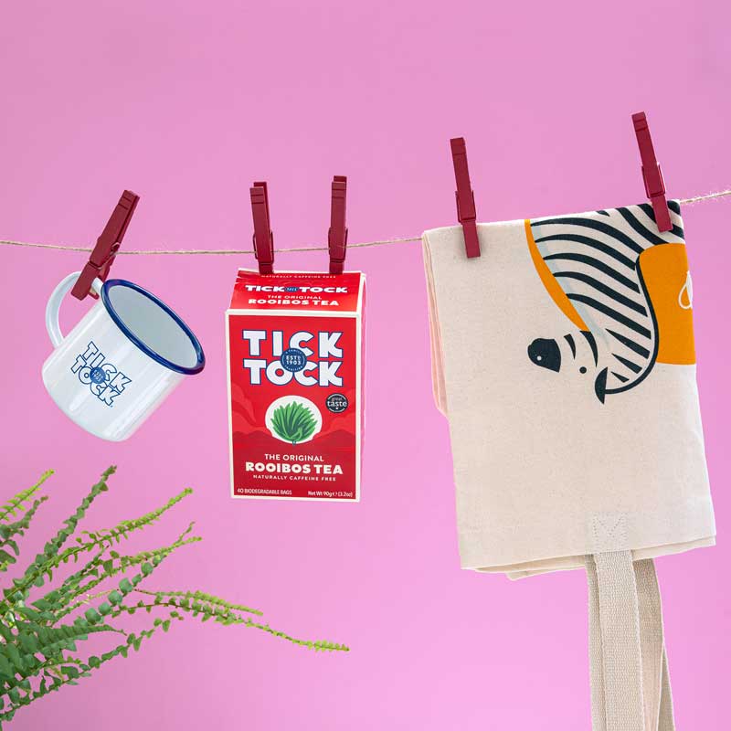 Original Rooibos hanging on a Washing Line with an Enamel Mug and Ginger Boost Bag.